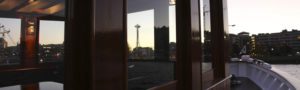 Space Needle in Seattle reflected in window of charter yacht