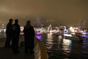 Guests watching Seattle christmas ships from bow on party cruise